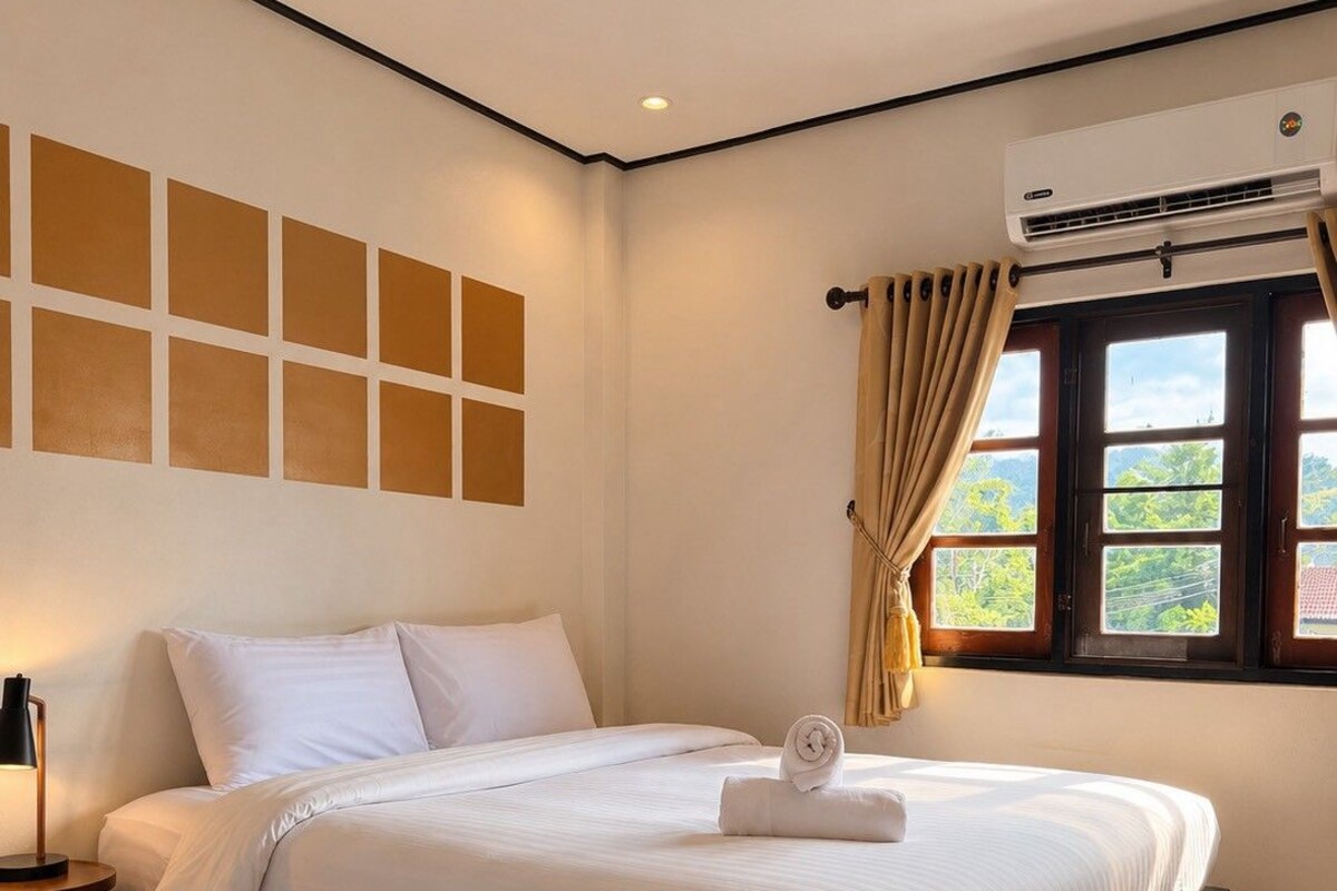 A hotel room with two beds, a window with curtains, an air conditioning unit, and a wall with a geometric pattern.
