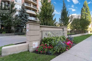 L’entrée d’un immeuble résidentiel, avec une enseigne indiquant « The Mansions of Avondale », et une borne d’incendie à proximité.