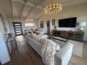 Ein modernes Wohnzimmer mit einer großen Couch, einem Couchtisch und einem Fernseher.