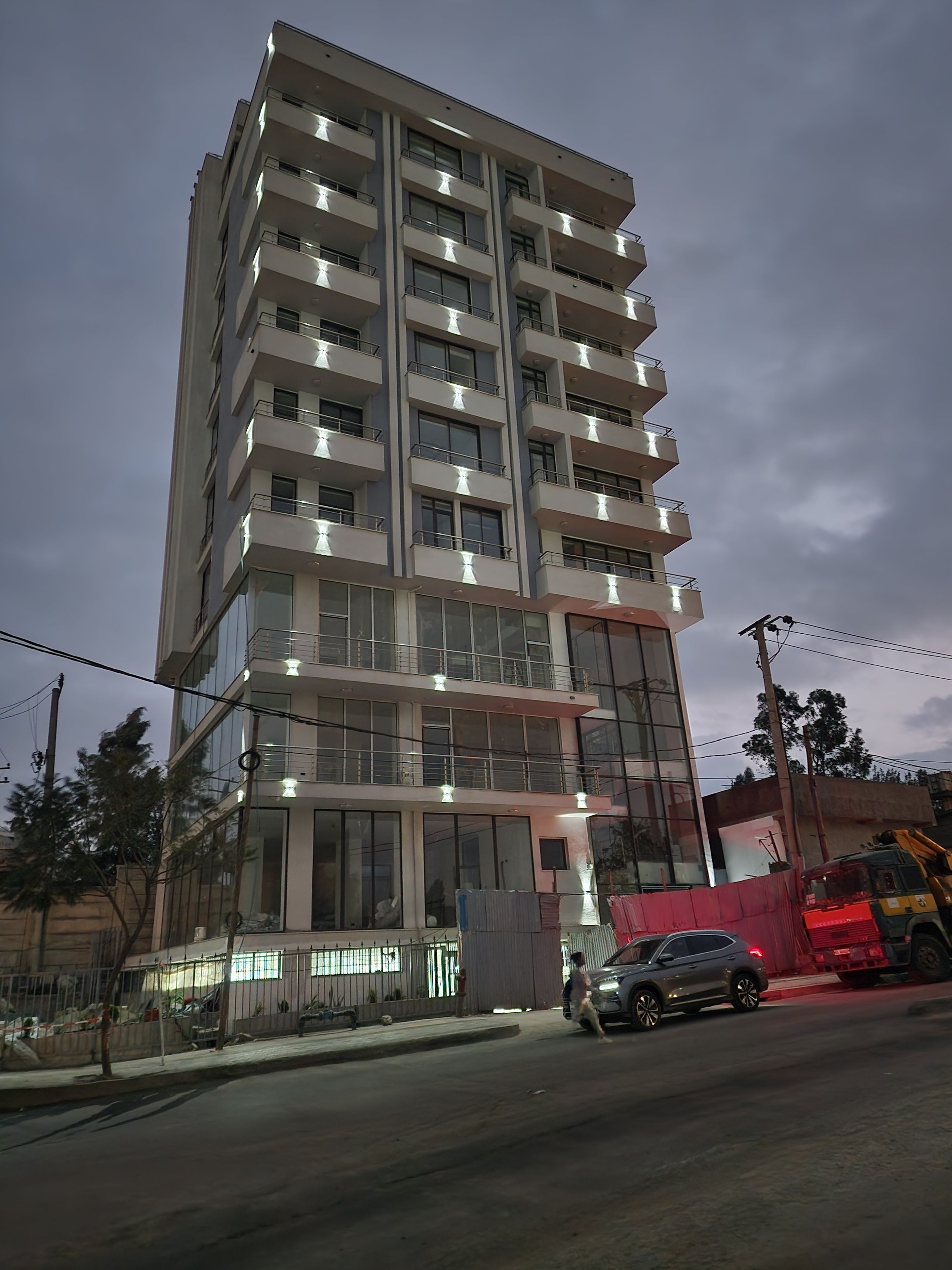 A multi-story building with balconies and large windows.