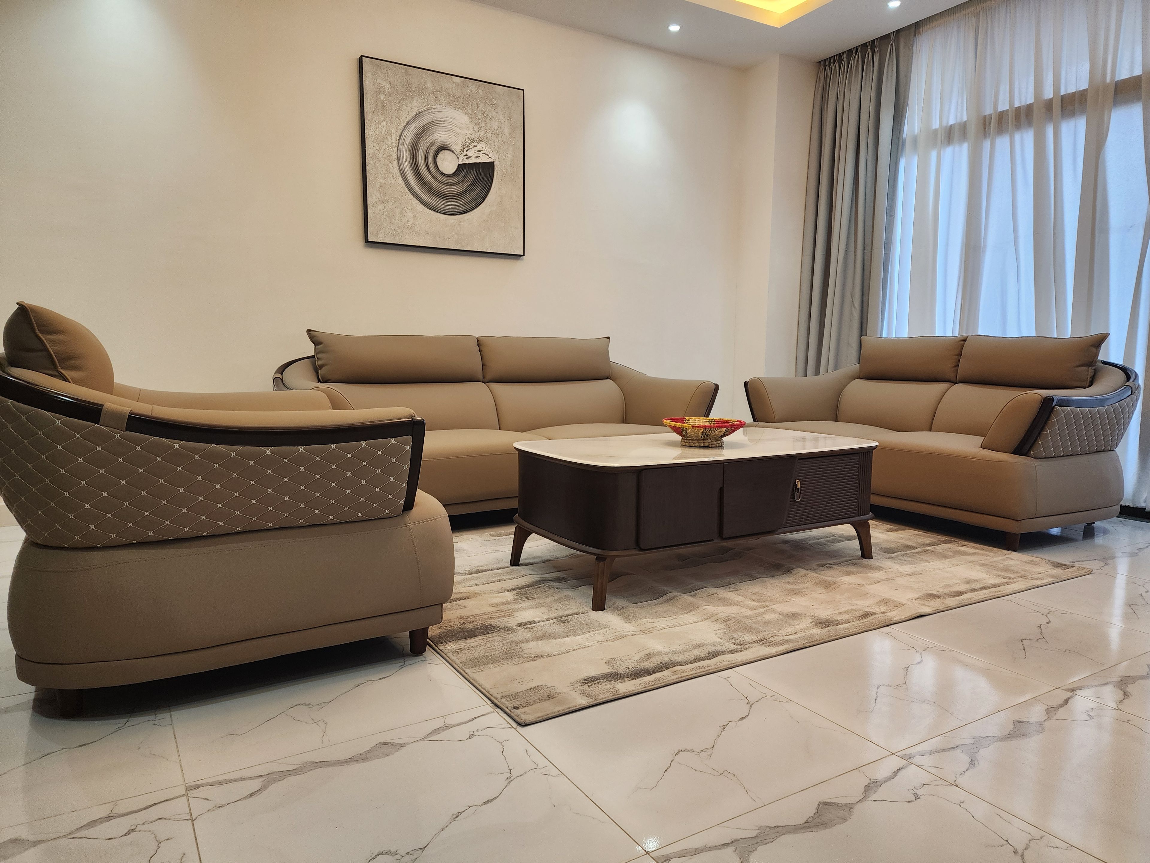 A modern living room with a sectional sofa, a coffee table, and a rug.