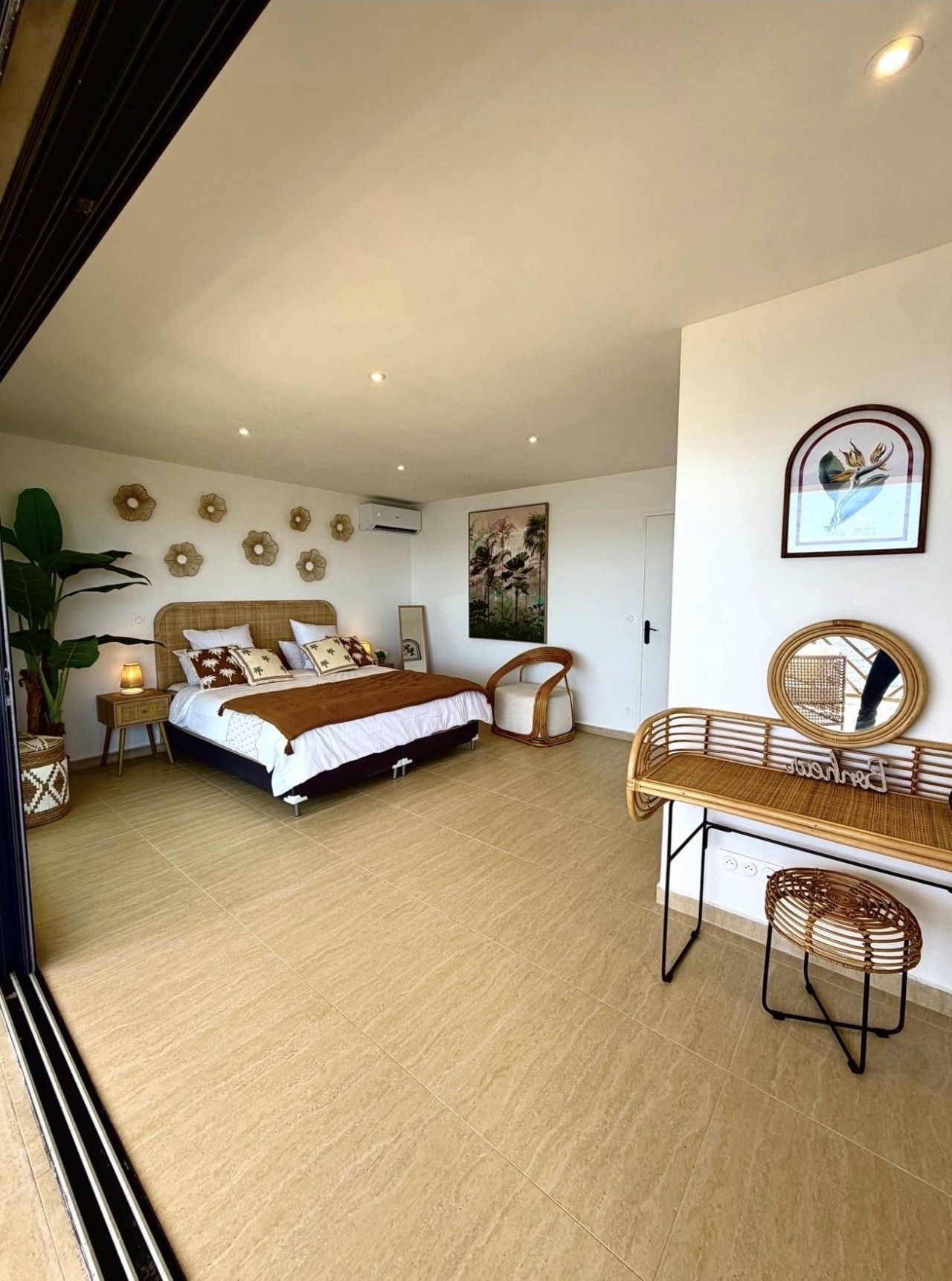 A bedroom with a bed, bedside tables, a chair, a desk, and a mirror.