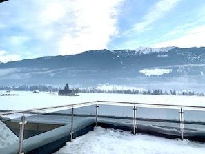 A snow-covered landscape with a mountain in the background and a metal railing in the foreground. - Chalet in Stuhlfelden Near Ski Slopes (Stuhlfelden)