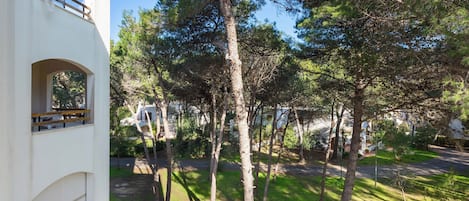 Zona residencial con un edificio blanco, un sendero pavimentado y árboles.
