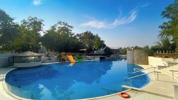 A swimming pool with a slide and a lifebuoy on the deck.