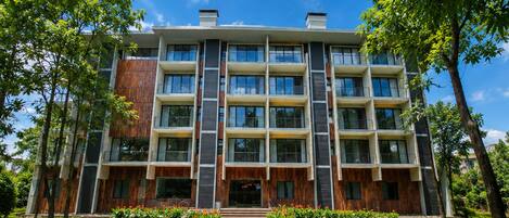 A multi-story building with a central courtyard, surrounded by trees and a well-maintained lawn.