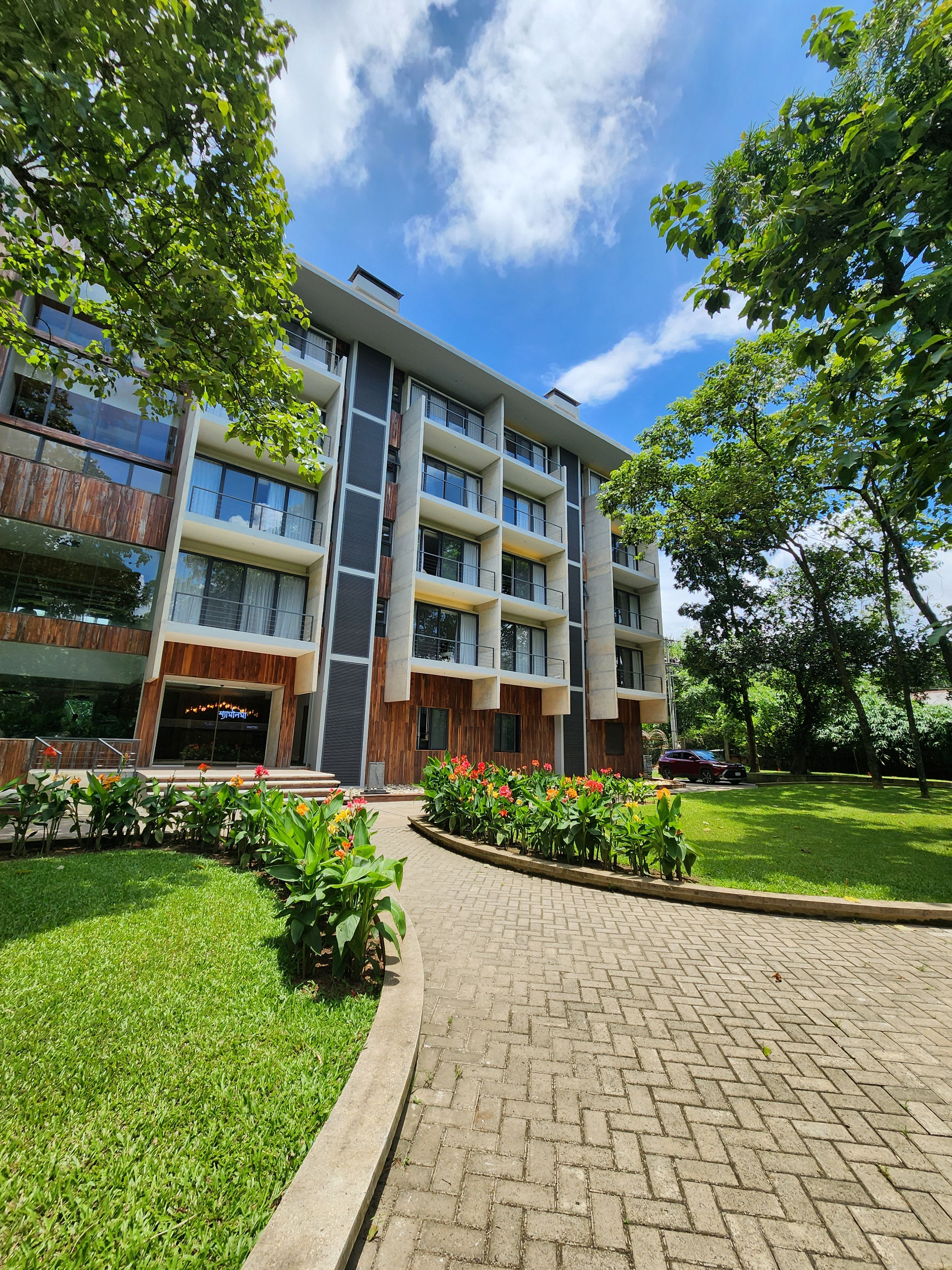 A multi-story building with a brick pathway leading to the entrance.