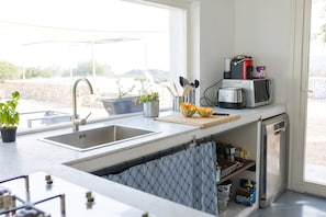 A kitchen with a sink, a microwave, and a coffee maker on the counter. - Tranquil 3-bedroom villa with swimming pool and beautiful country views (Sicilia)