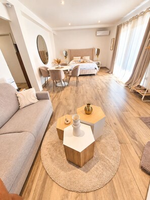Un salon moderne comprenant un canapé, une table basse et un coin repas avec des chaises et une table.