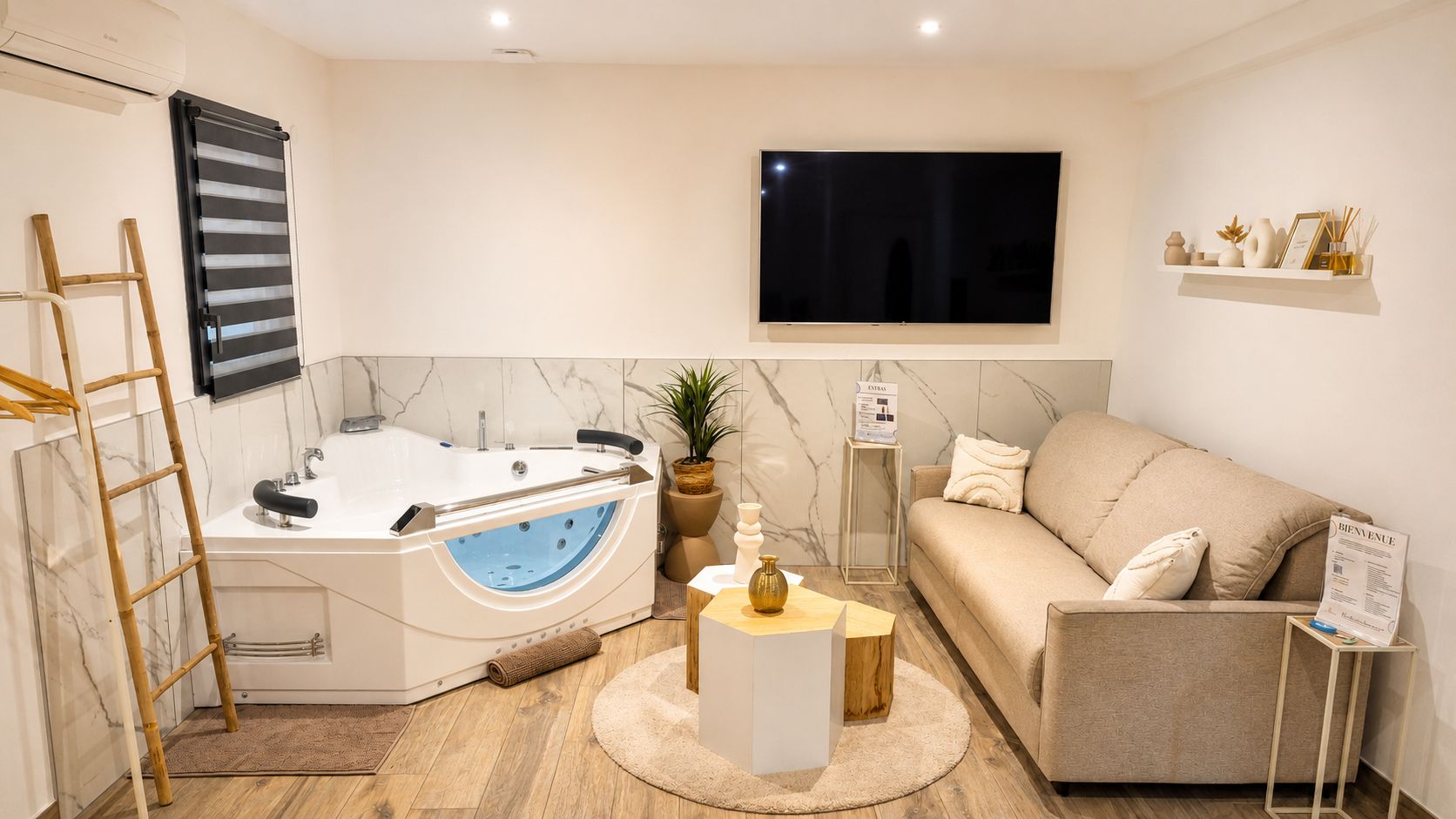 Une salle de bain moderne avec une baignoire, une échelle en bois, un mur en marbre, un téléviseur et un canapé.