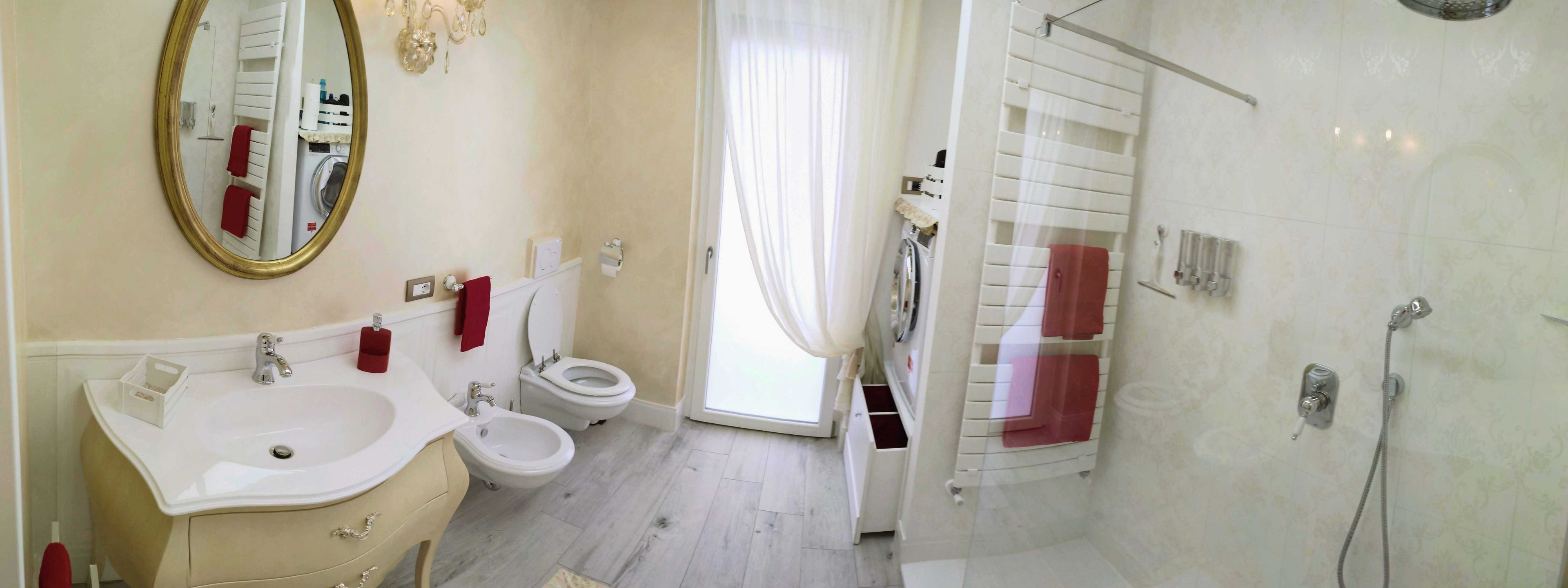 A bathroom with a sink, toilet, bidet, and shower.