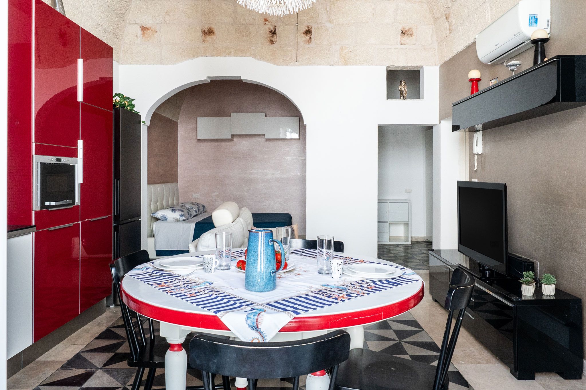 Un espace de vie compact comprenant un coin repas, une kitchenette et un téléviseur.