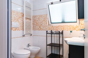 Ein Badezimmer mit Toilette, Bidet und Waschbecken.