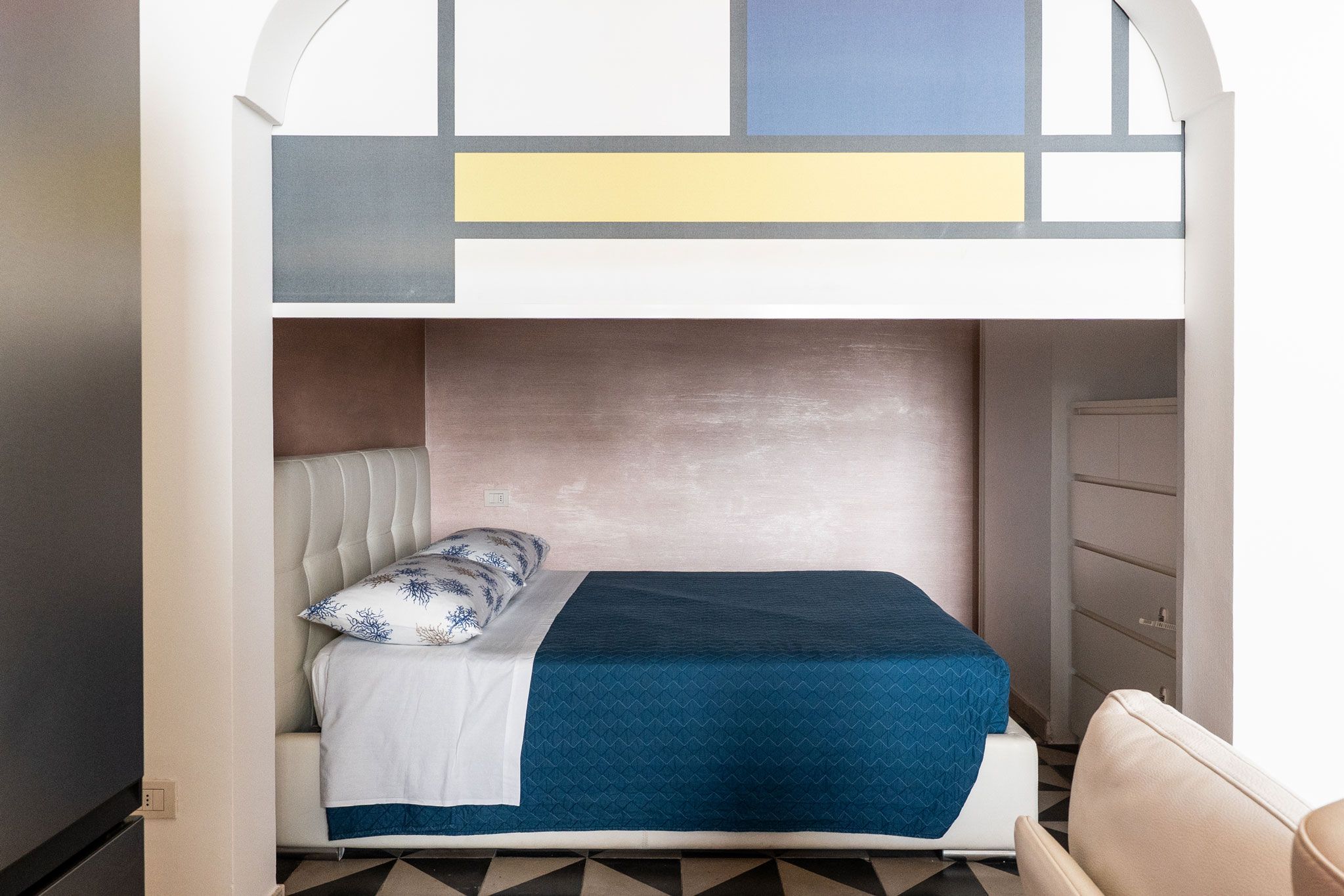 Un lit superposé avec une tête de lit, un oreiller et une couverture.