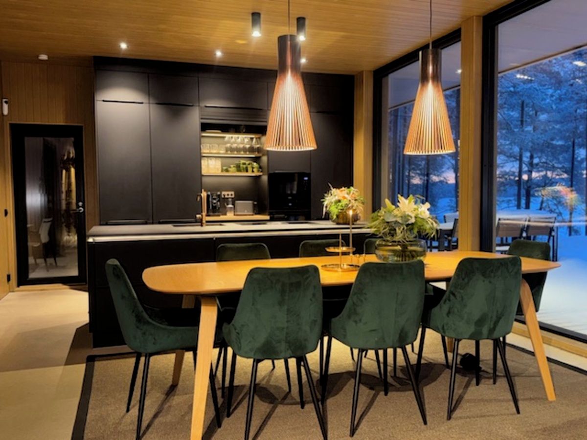 A modern kitchen with dark cabinetry, a central island, and pendant lighting.