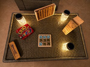 Ein gewebter Tablett mit UNO-Karten, einem hölzernen Spielbrett und zwei zylindrischen Behältern.