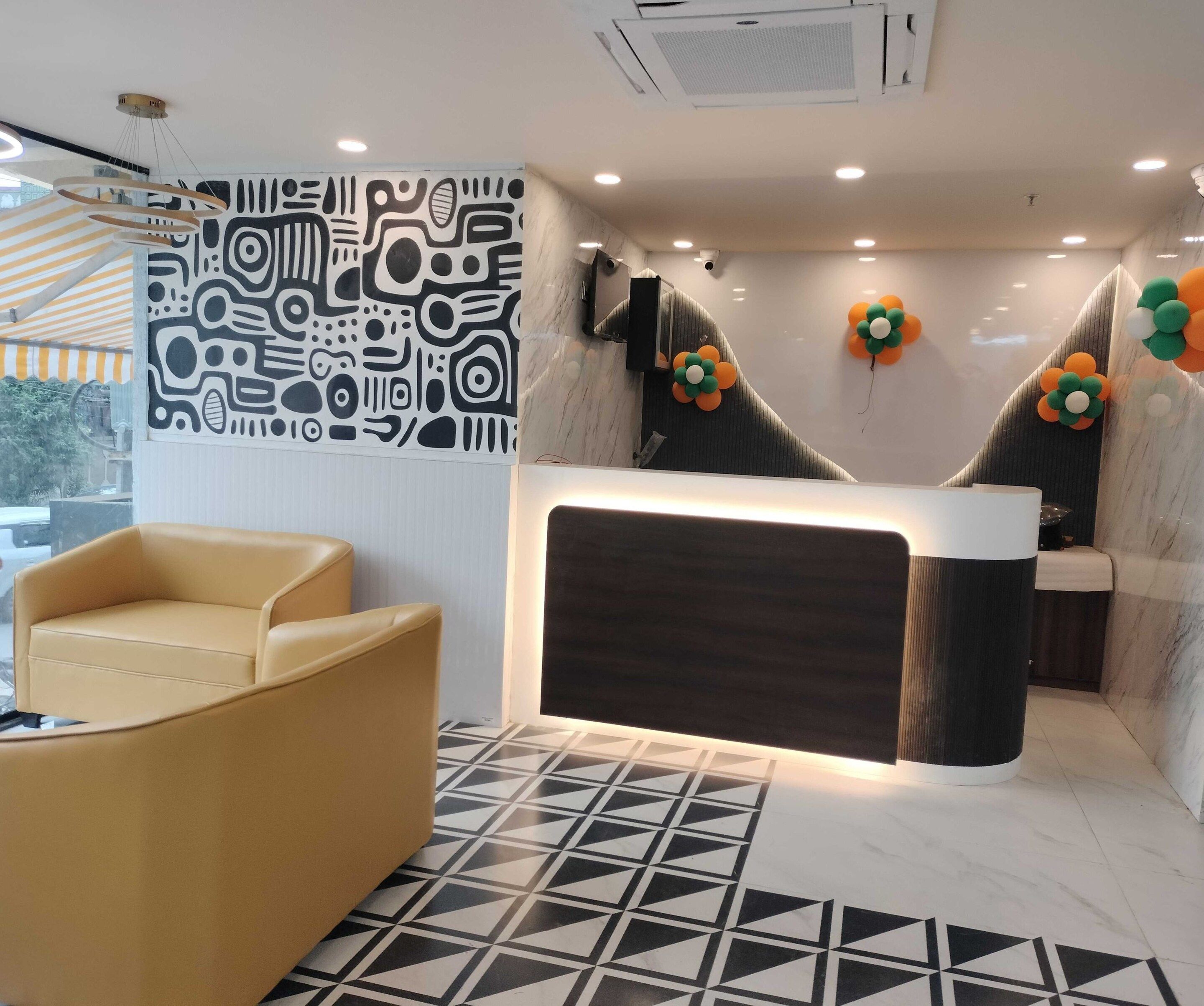Uma área de recepção com design moderno, incluindo uma parede com padrão, um balcão de atendimento e uma área de estar com piso estampado.