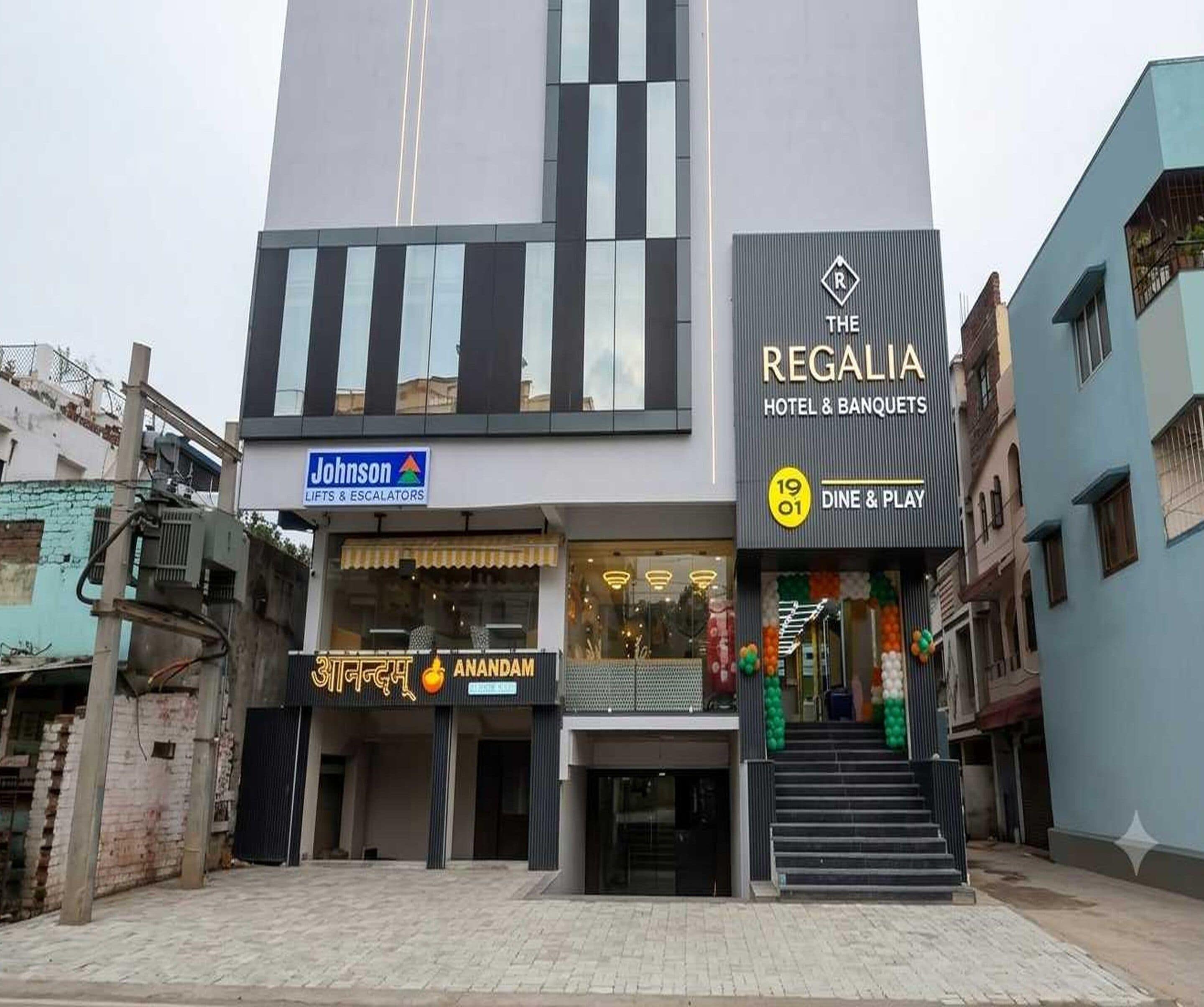 A hotel with a modern facade, a visible entrance, and a sign for 'Johnson Lifts & Escalators' indicating nearby facilities.
