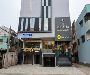 A hotel with a modern facade, a visible entrance, and a sign for 'Johnson Lifts & Escalators' indicating nearby facilities.