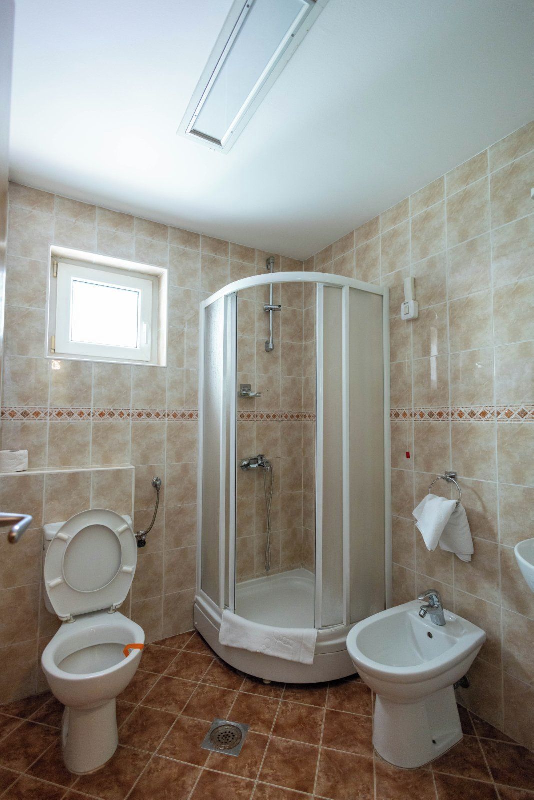 Ein Badezimmer mit Dusche, Toilette, Bidet und Waschbecken.