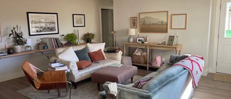 A living room with a sofa, armchairs, a coffee table, and a bookshelf.