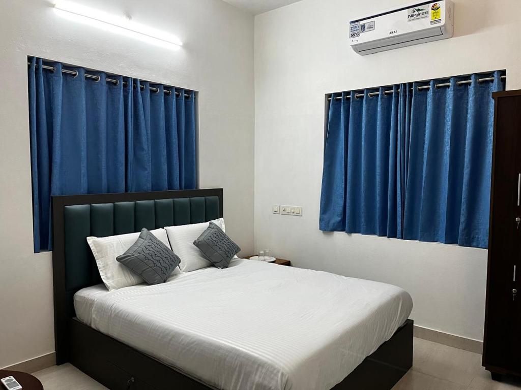 Ein Schlafzimmer mit Bett, Vorhängen, einer Klimaanlage und einem Nachttisch.