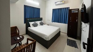 A bedroom with a bed, a desk, a chair, a ceiling fan, and a TV. - Rivera Home | Lake View Homestay in Kadalundi (Balathiruthi)