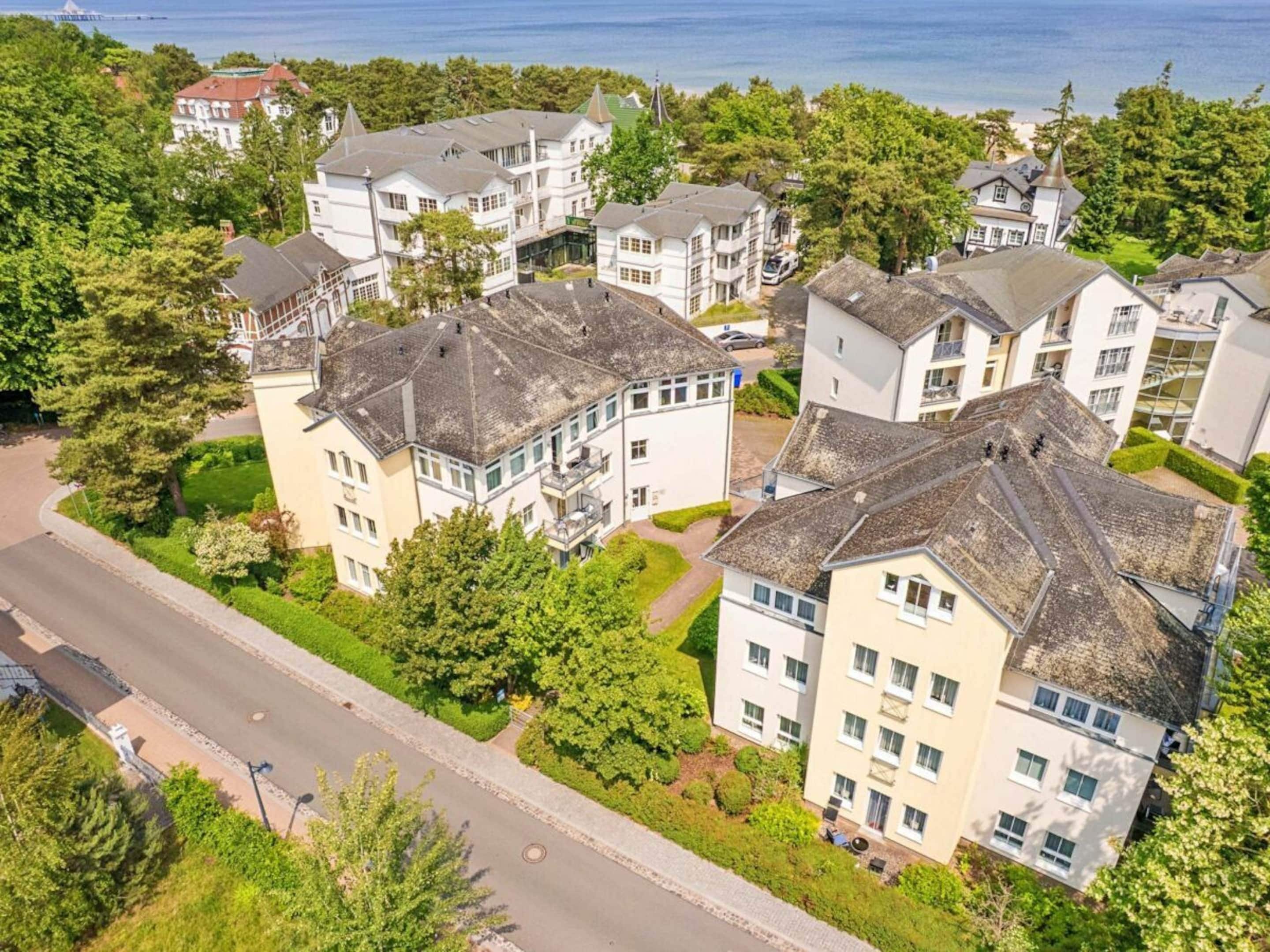 Un quartier résidentiel composé de plusieurs maisons à deux étages, une route et une étendue d’eau en arrière-plan.