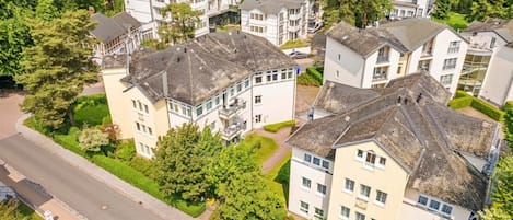 Un barrio residencial con varias casas de dos pisos, una calle y una masa de agua al fondo.