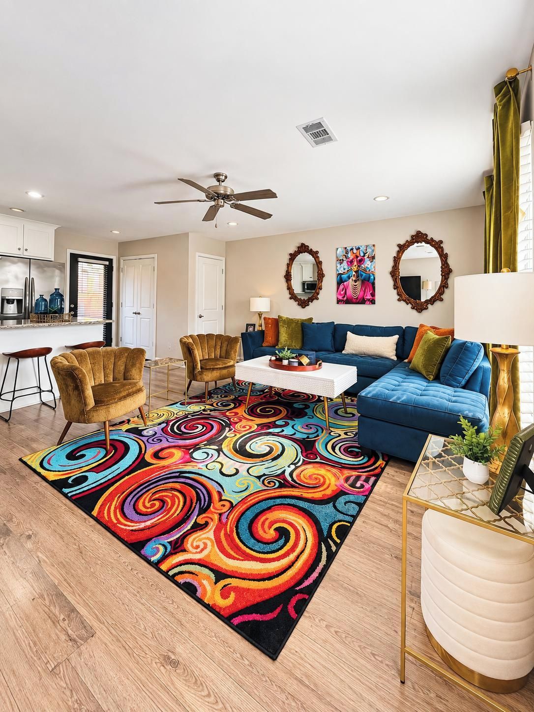 A living room with a blue sofa, a patterned rug, and a ceiling fan.