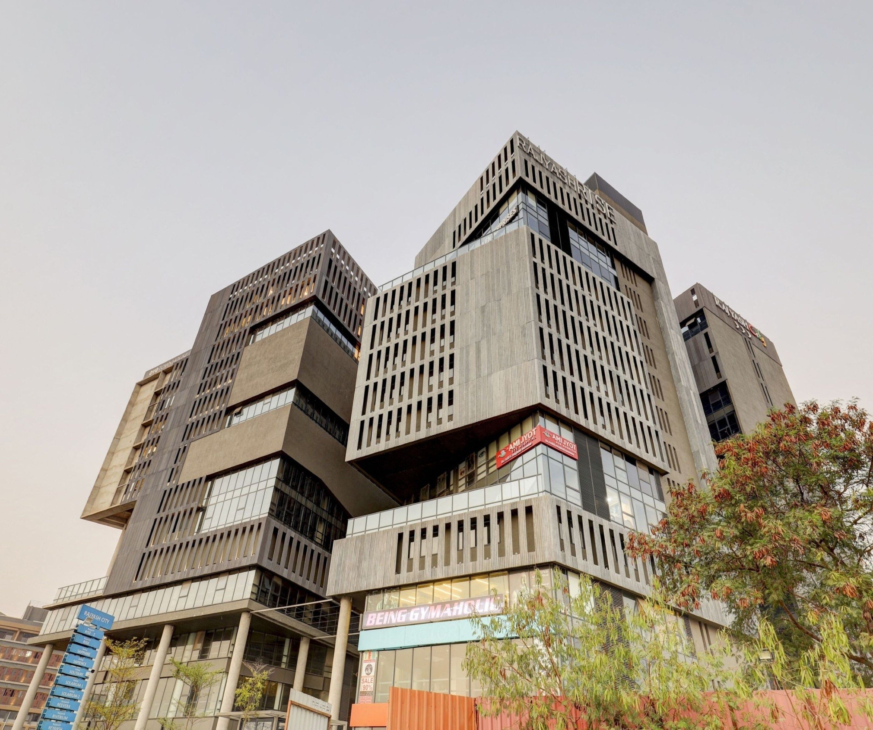 A multi-story building with a modern architectural design, featuring a prominent sign for a gym.