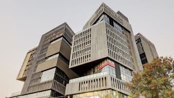 A multi-story building with a modern architectural design, featuring a prominent sign for a gym.