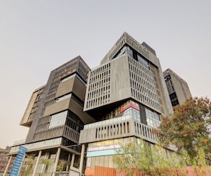 A multi-story building with a modern architectural design, featuring a prominent sign for a gym.