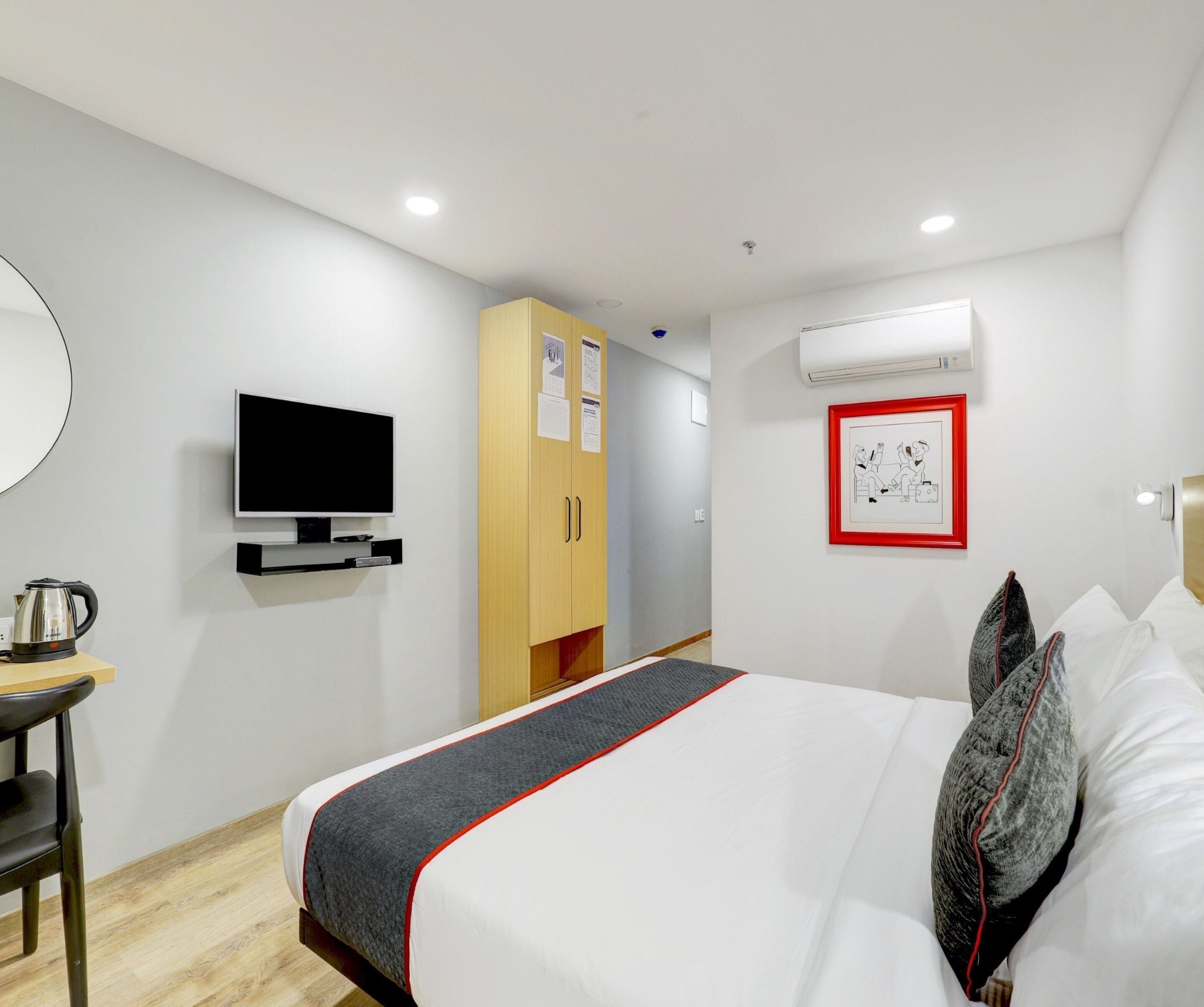 Une chambre d’hôtel équipée d’un lit, d’une télévision, d’une armoire et d’un appareil de climatisation.