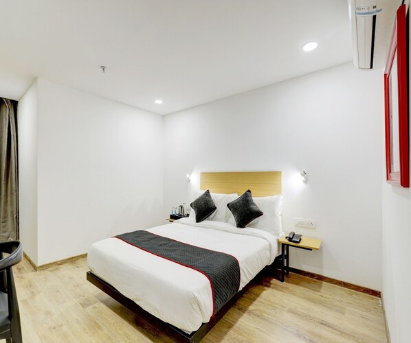 A hotel room with a bed, bedside table, and a phone.