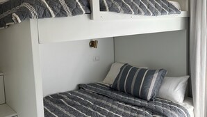 Ein Etagenbett mit einer Unterliege und einem Kopfteil, jeweils mit gestreifter Bettwäsche.
