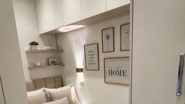 Ein Schlafzimmer mit Bett, Nachttischen, einem Kleiderschrank und Wandregalen.