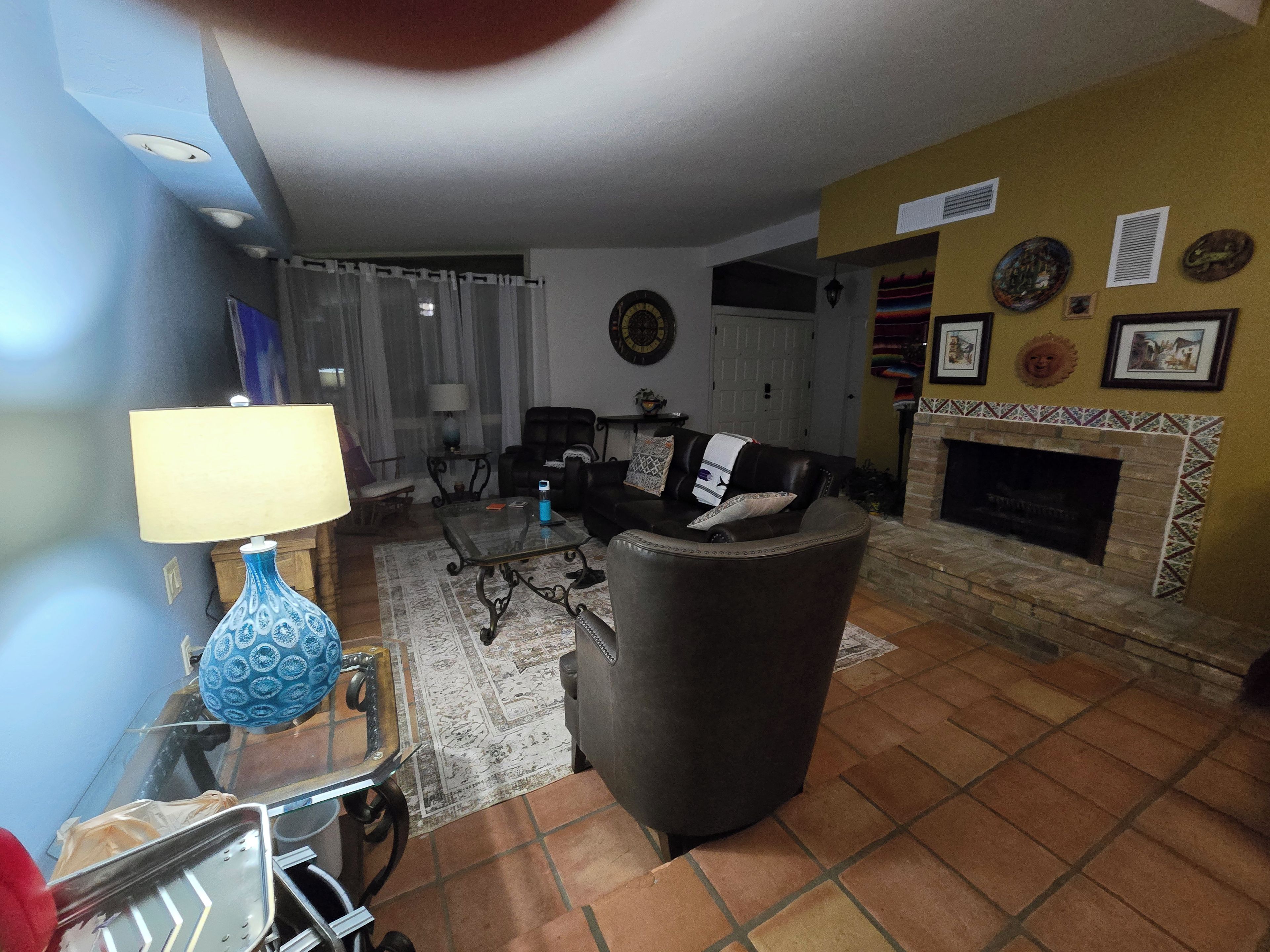 A living room with a fireplace, a sofa, a coffee table, and a lamp.