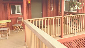 A wooden deck with a railing, a table, and two chairs. - Peaceful 2 bedroom log cabin in Durango perfect for a relaxing getaway. Pets ok. (Durango)
