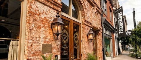 Un bâtiment en briques avec une porte d’entrée en bois, deux plantes en pot et une enseigne indiquant « The Keystone Hotel ».