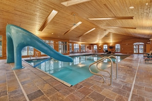 An indoor swimming pool with a slide, wooden ceiling, and stone flooring. - Private 35-Acre Resort Near Wisconsin Dells - Indoor Pool, Golf Sim, Sleeps 30+ (Camp Douglas)