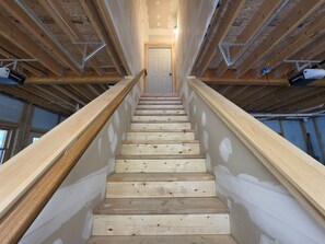 A staircase with wooden steps leading to a door at the top.