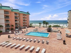 A resort with a swimming pool, lounge chairs, and a view of the beach. - Modern Ocean View Escape (Indian Shores)