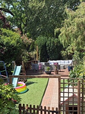 A fenced backyard with a slide, inflatable pool, and outdoor seating area. - Beautiful 400 yr old thatch house.Sleeps 11, dog friendly,close to beaches,moors (Combeinteignhead)