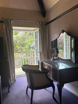 A room with a vanity, a chair, and a large window with curtains. - Beautiful 400 yr old thatch house.Sleeps 11, dog friendly,close to beaches,moors (Combeinteignhead)