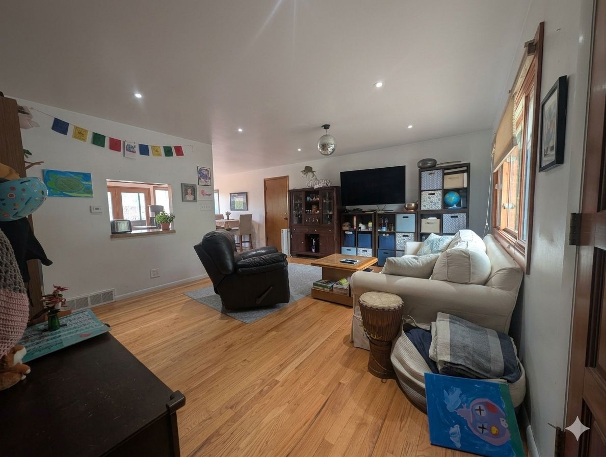 Una sala de estar con sofá, sillón, mesa de centro y televisor.