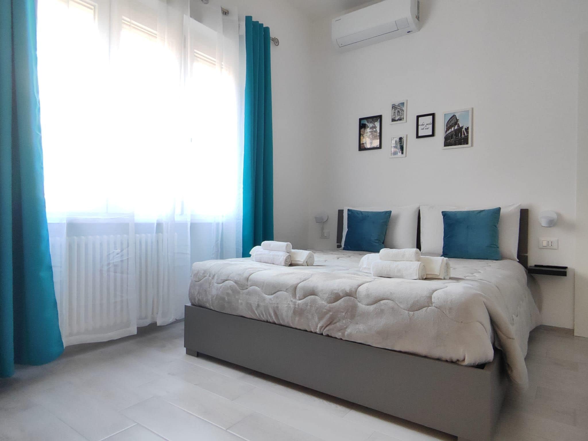 Ein Schlafzimmer mit Bett, Vorhängen und Bildern an der Wand.