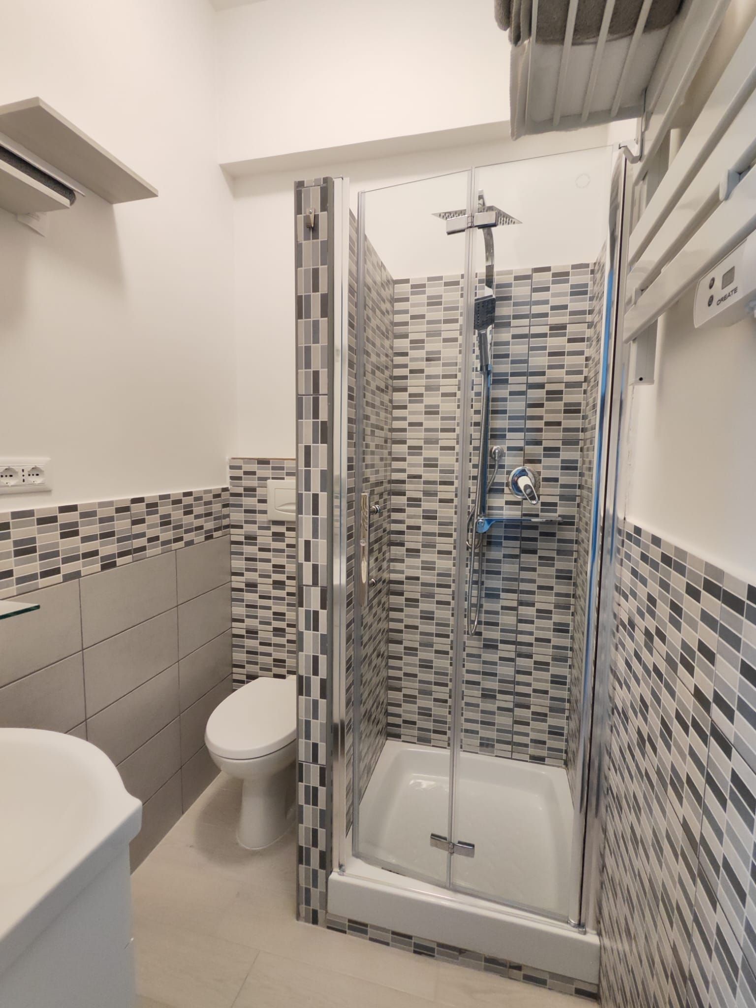 Ein modernes Badezimmer mit einer Duschkabine, einer Toilette und einem Waschbecken.