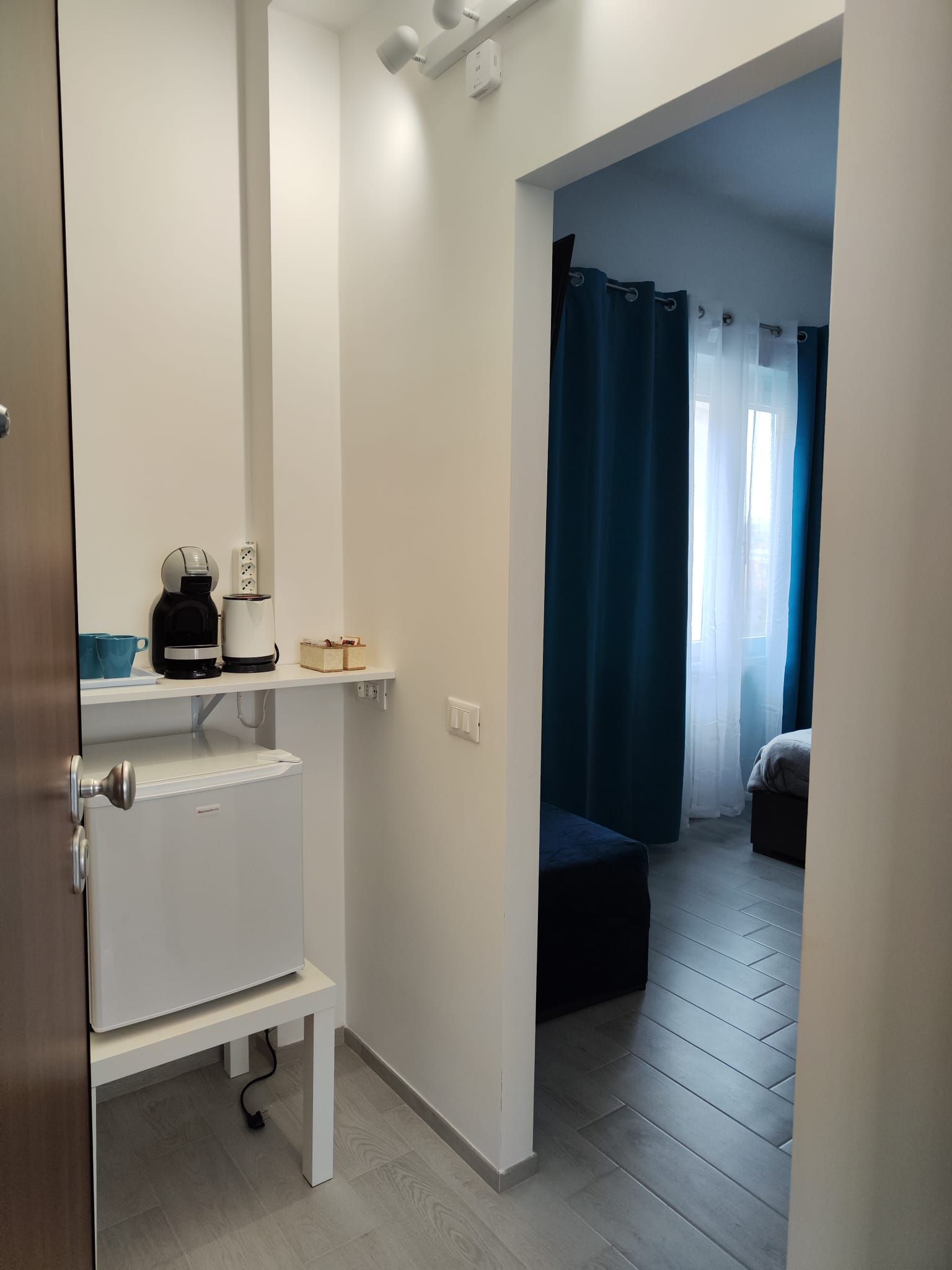 Ein Hotelzimmer mit Küchenzeile, einem Bett und Blick nach draußen.