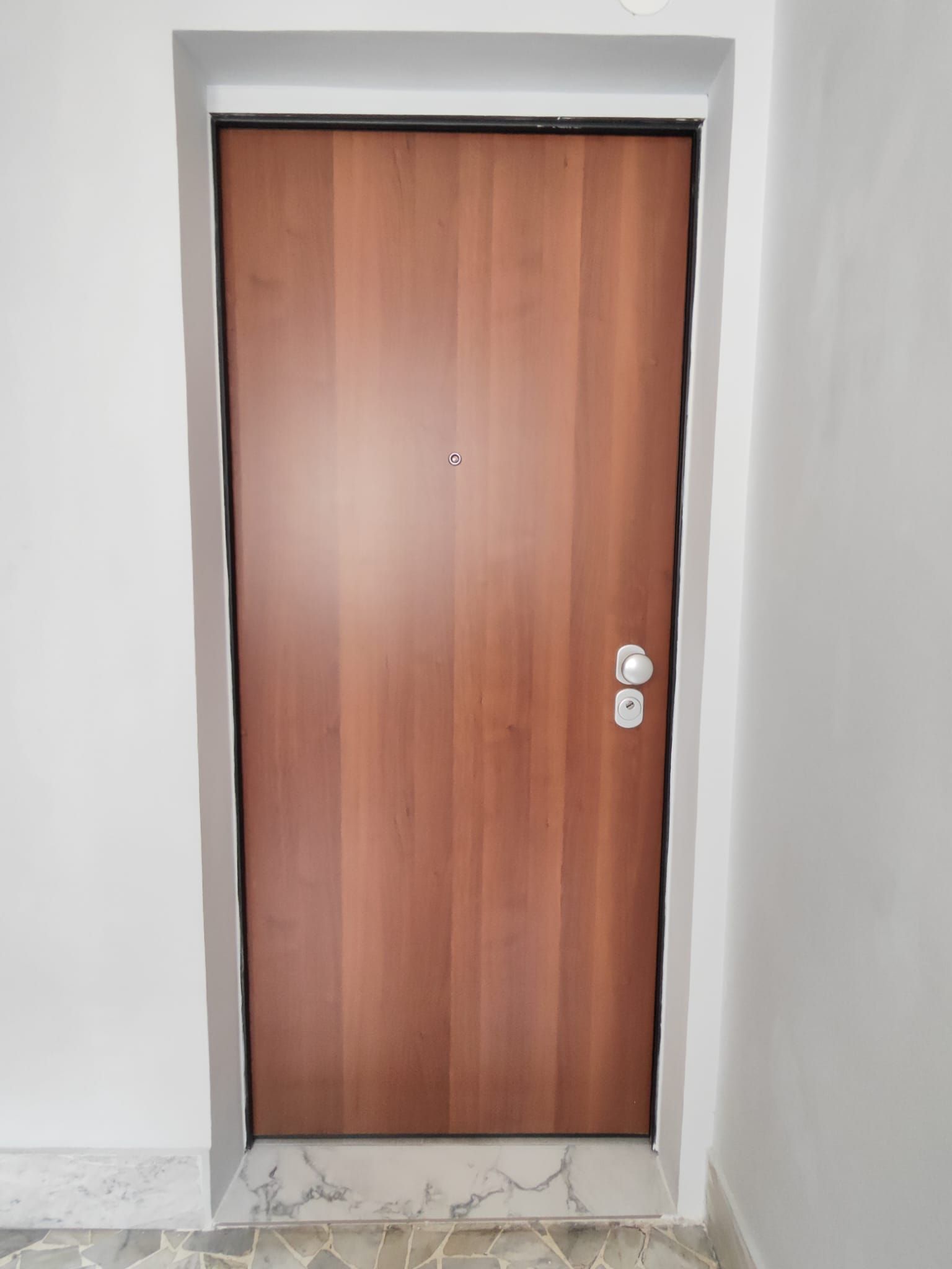 Une porte en bois fermée, dotée d’une simple poignée et d’un trou de serrure.